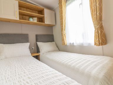 A bedroom with two beds and a window at Perran Sands Holiday Park - 621 Chy-an-Mor Perranporth