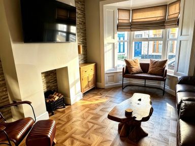 A living room with a television and wooden furniture at Jacks Place in Whitby