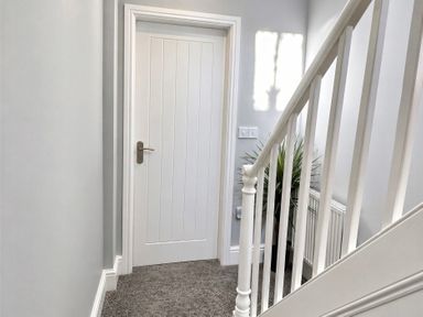 A hallway with a staircase and a door at Jacks Place in Whitby