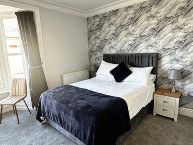 A bedroom with a bed and chair at Jacks Place in Whitby