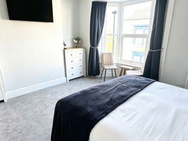 A bedroom with a bed and dresser at Jacks Place Whitby
