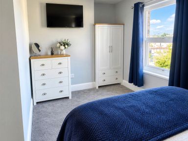 A bedroom with a television and wardrobe at Jacks Place in Whitby