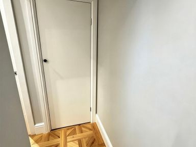 A hallway with a door and wooden flooring at Jacks Place in Whitby