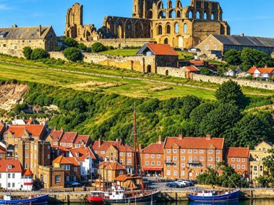 A harbor with buildings and ruins overlooking the water at Jacks Place in Whitby