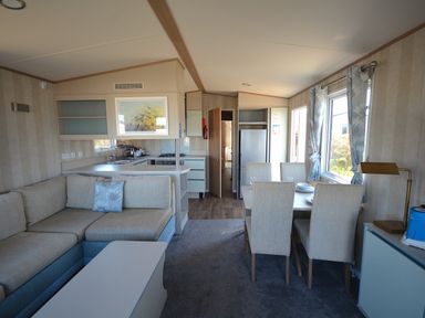 A living room with sofa and dining area at Perran Sands Holiday Park - 725 Kernow View Perranporth