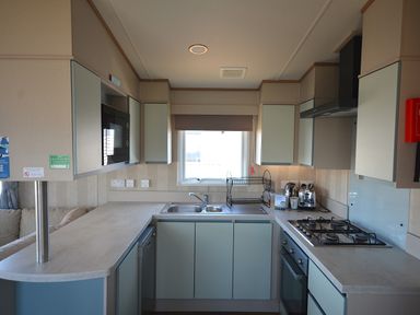 A kitchen with sink and microwave at Perran Sands Holiday Park - 725 Kernow View in Perranporth