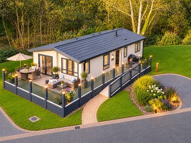 A house with a deck and seating area at Hoburne Devon Bay - Woodland Glade 24 Paignton
