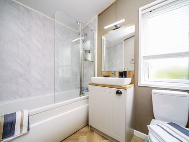 A bathroom with a bathtub, sink, and toilet at Hoburne Devon Bay - Woodland Glade 24, Paignton