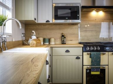 A kitchen with sink, stove, and countertop at Hoburne Devon Bay - Woodland Glade 24 in Paignton