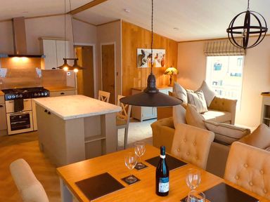 An open plan living area with kitchen and dining space at Hoburne Devon Bay - Woodland Glade 24 in Paignton