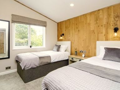 A bedroom with two beds and a window at Hoburne Devon Bay - Woodland Glade 24 Paignton