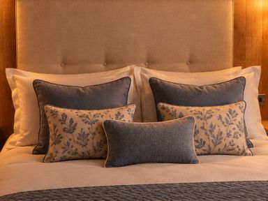 A bed with decorative pillows at Hoburne Devon Bay - Woodland Glade 24 Paignton