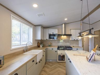 A kitchen with modern appliances and cabinetry at Hoburne Devon Bay - Woodland Glade 24 Paignton
