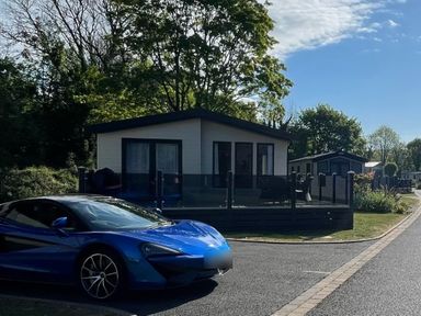 A house with a car parked in front at Hoburne Devon Bay - Woodland Glade 24 Paignton