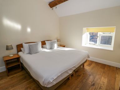 A bedroom with a double bed two bedside tables and lamps and a window with a yellow blind at Little Cowarne Court in Little Cowarne near Bromyard