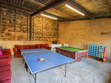 A game room with a ping pong table billiards table red sofas and a connect four game at Little Cowarne Court in Little Cowarne near Bromyard