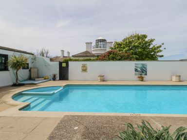 An outdoor swimming pool with steps and surrounding plants at Old Higher Lighthouse Branscombe Lodge Portland Bill