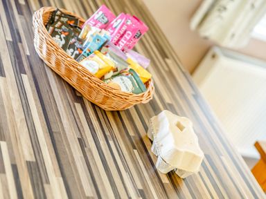 A wooden table with a basket of snack packs and an empty egg carton at Lavender Lodge in Charlton Horethorne near Sherborne
