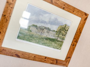 A framed painting of a large house with columns and trees in a grassy field at Lavender Lodge in Charlton Horethorne near Sherborne