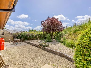 A garden area with gravel ground seating area and a tree at Lavender Lodge in Charlton Horethorne near Sherborne