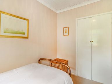 A bedroom corner with a bed a wicker basket two framed pictures and a white closet door at Reiver's Rest in Hesleyside near Bellingham