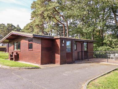 An outdoor log cabin with windows and a deck at Primrose Lodge in Saltburn-by-the-Sea
