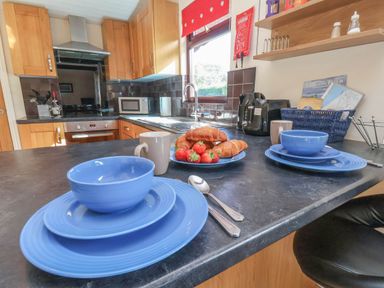 A kitchen with blue dishes and food on the counter at Primrose Lodge, Saltburn-by-the-Sea