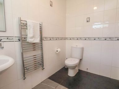 A bathroom with a toilet, sink, towel rack at Primrose Lodge Saltburn-by-the-Sea