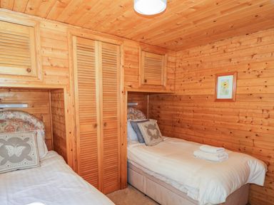 A wooden bedroom with two single beds and a framed picture at Striding Edge White Cross Bay near Troutbeck Bridge