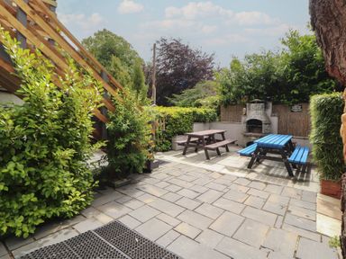 A garden with seating and a barbecue at Eden House in Bardsea