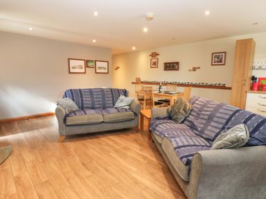 A living room with a sofa and dining area at Cooper Cottage in Potto near Stokesley