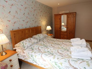 A bedroom with a bed and wardrobe at Cooper Cottage Potto near Stokesley