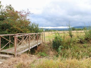 A bridge over grass and trees in a field at Cooper Cottage in Potto near Stokesley