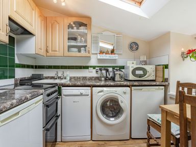 A kitchen with appliances including an oven toaster microwave dishwasher and washing machine at Hillside Cottage in Peasedown St John near Bath