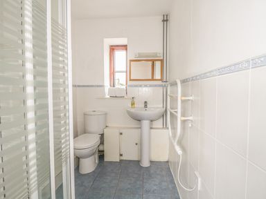 A bathroom with a toilet sink mirror and shower at High Park Barn in Uffculme Blackdown Hills