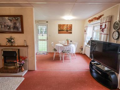 A dining room with a table and chairs at The Lodge in Old Buckenham near Attleborough