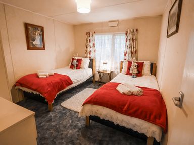 A bedroom with two beds and a window at The Lodge in Old Buckenham near Attleborough