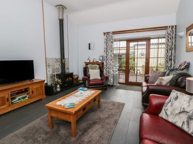 A living room with a fireplace and seating area at Yr Hen Llaethdy near Blaen-Cil-Llech near Newcastle Emlyn
