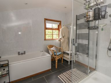 A bathroom with a bathtub and shower at Yr Hen Llaethdy Blaen-Cil-Llech near Newcastle Emlyn