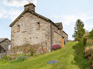 A stone cottage with grass lawn and a metal gate at Moresdale Bank Cottage Lambrigg near Sedbergh and Kendal