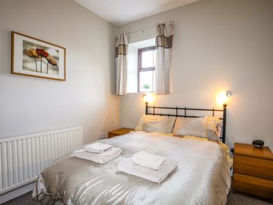 A bedroom with a double bed and bedside tables at Penrallt Cottage in Y Felinheli near Caernarfon