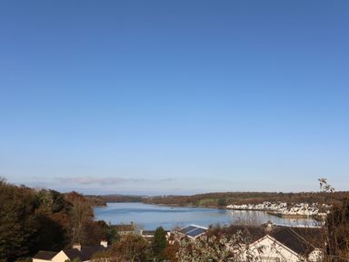 A view of a river with houses and trees on both sides at Penrallt Cottage in Y Felinheli near Caernarfon