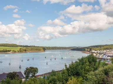 A river with boats anchored and houses along the shoreline at Penrallt Cottage in Y Felinheli near Caernarfon