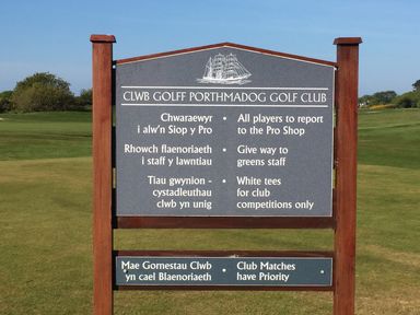 A golf course sign with rules and instructions in Welsh and English at Porthmadog Golf Club