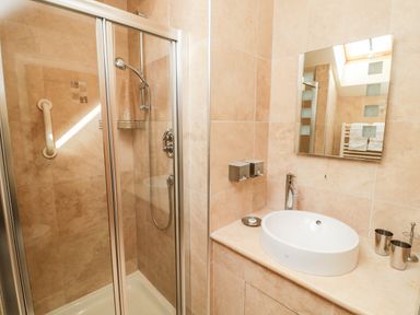 A bathroom with a shower enclosure sink mirror and towel rack at The Granary in Longframlington near Alnwick