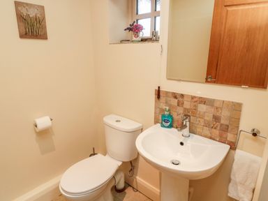 A bathroom with a toilet sink mirror and hand soap dispenser at The Granary in Longframlington near Alnwick