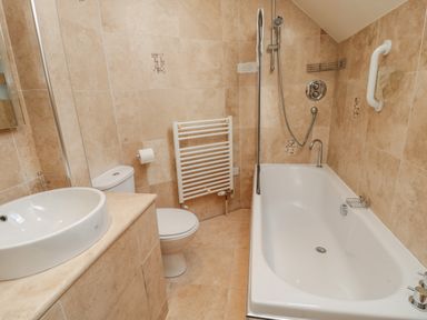 A bathroom with a bathtub shower toilet sink and towel radiator at The Red Barn Longframlington near Alnwick