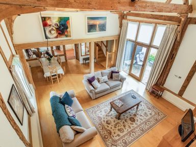 A living room with two sofas a wooden coffee table and a dining table at Ducksfoot Barn Bush Green near Pulham Market