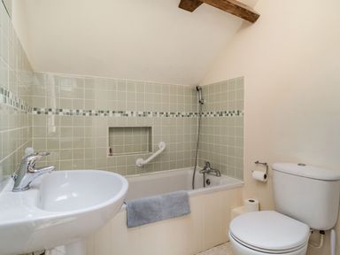 A bathroom with a bathtub shower sink and toilet at Ducksfoot Barn in Bush Green near Pulham Market