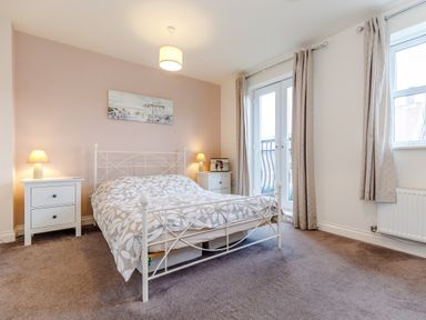 A bedroom with a double bed two bedside tables lamps and curtains at Sunrise The Bay near Filey